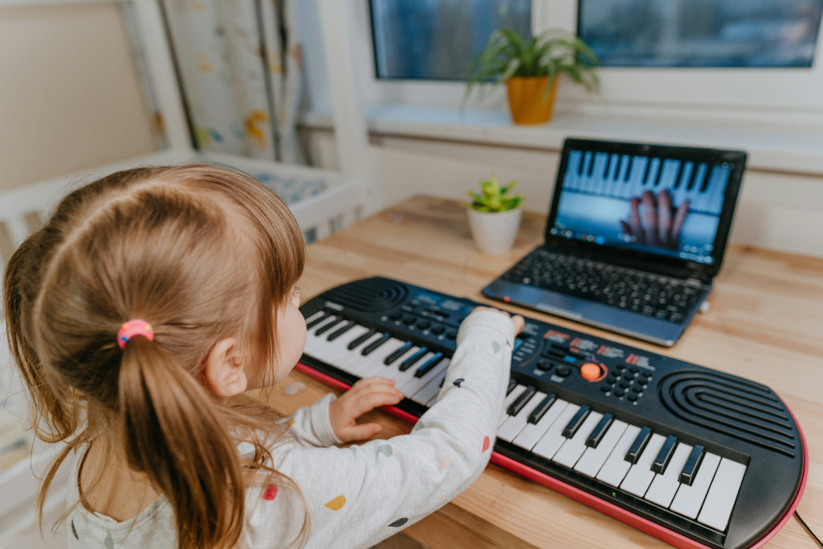 child learning keyboard with music toy at home