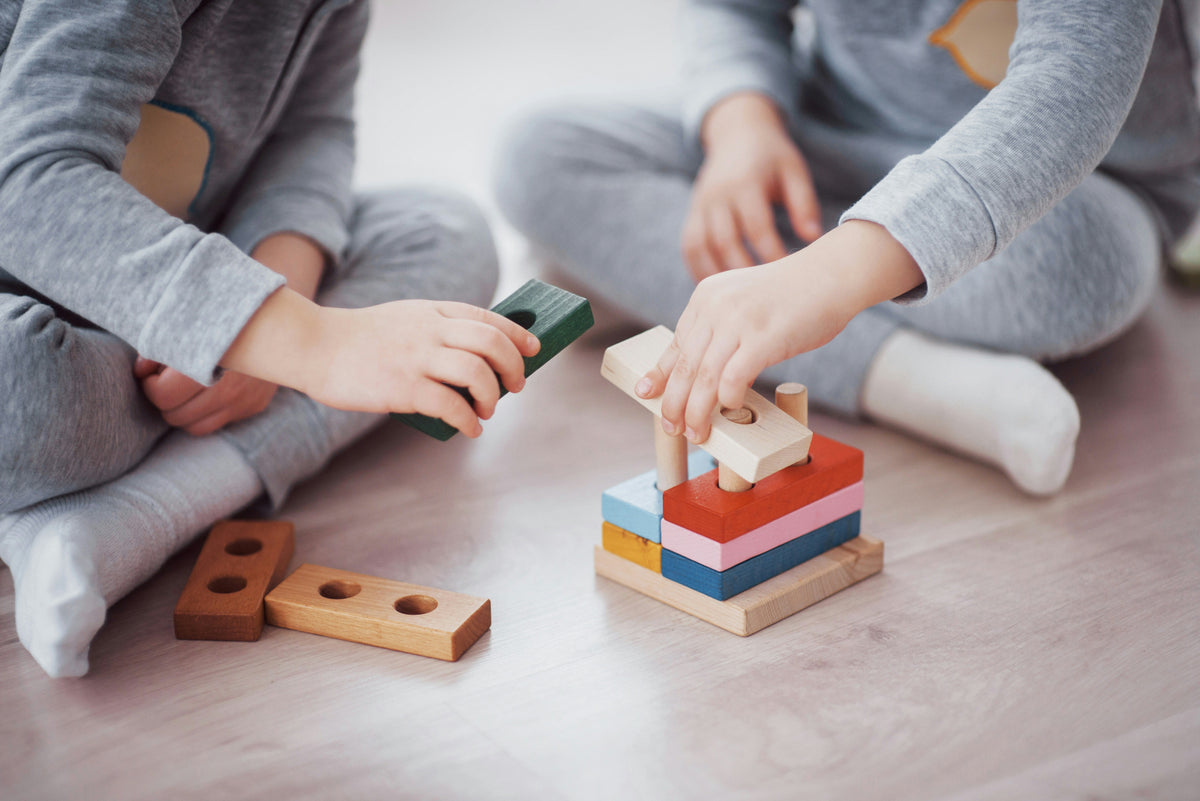 Children stacking wooden blocks, creative building toy activity