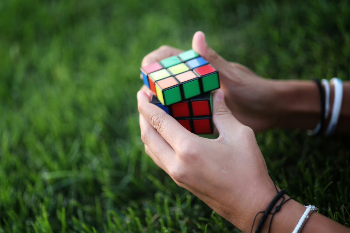 Hands solving a puzzle cube, focused and engaging brain activity