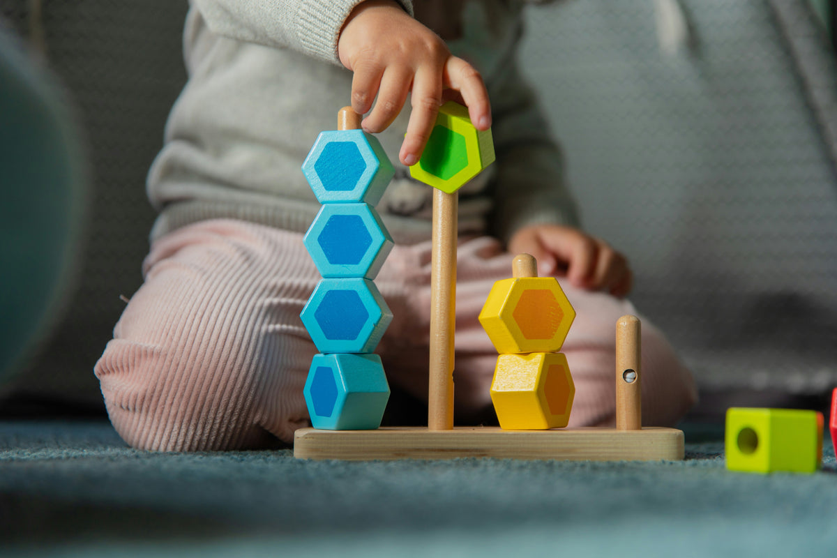 Child playing with wooden sorting toys, montessori learning activity