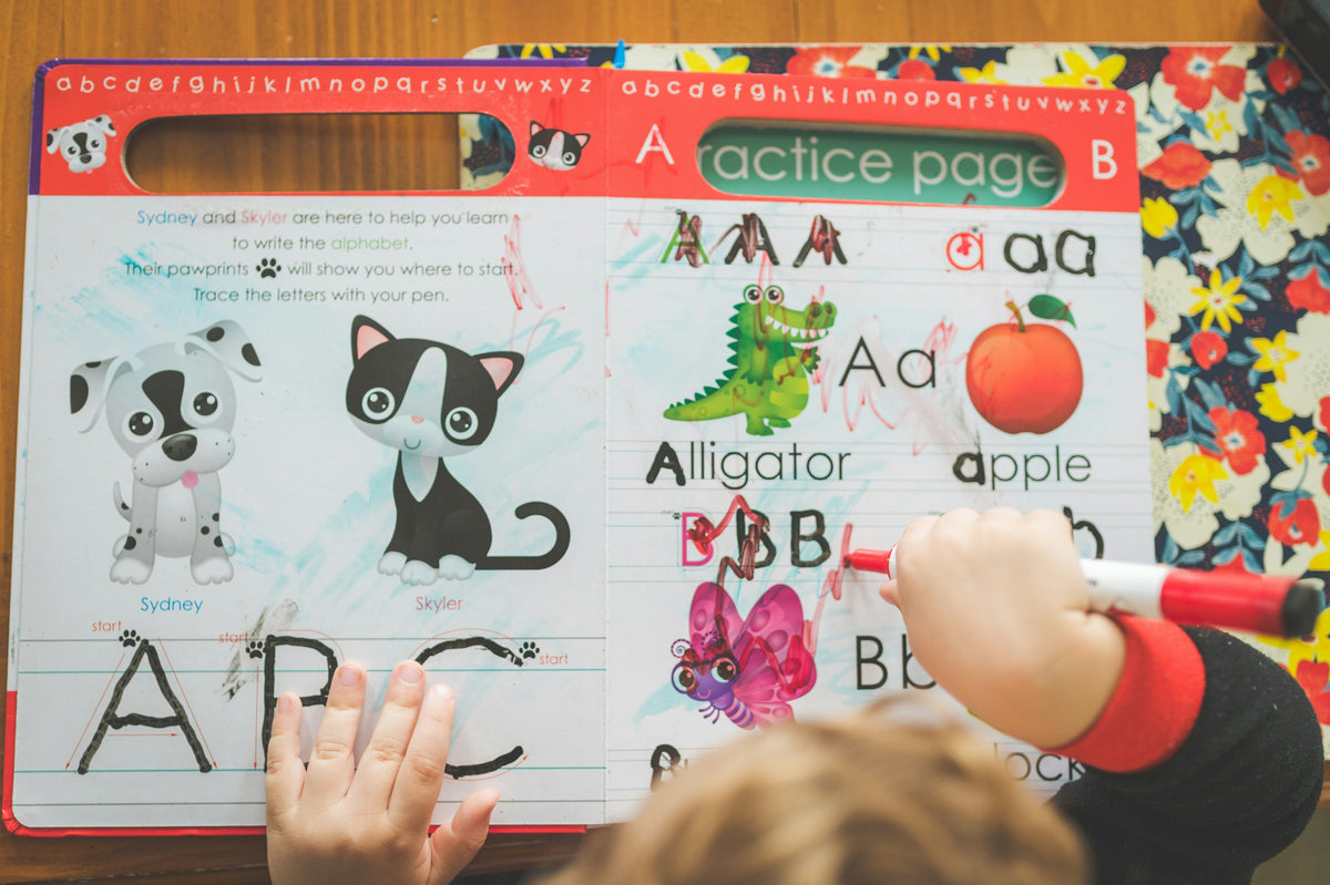 child drawing and coloring activity book with pencils